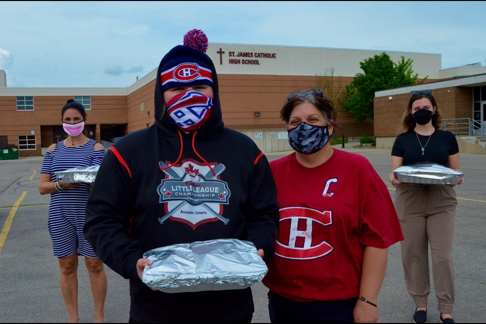 Eric Lachance and his mother Martha, were first to arrive with potato salad, flanked by teachers Cindy Della Croce and Victoria Nestico.