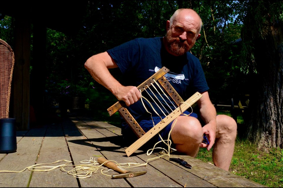 Jeremy Shute repairs his canoe seat in preparation for the fifth leg of his Speed to Sea voyage