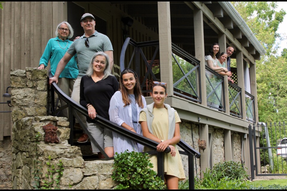 Decendents of man well known in Elora, Francis Dalby stand on the staircase of a house he built in 1862. Left to Right. Ginnie Dalby Baxter (great grand daughter of Francis Dalby), her son and daughter Paul Baxter and Cathie Abernethy, and her grandchildren, Nicole Abernethy and Sydney Abernethy. Owners of the house Vince Agostino stands on the balcony with his wife Suzie Agostino and daughter Nicole Agostino. Anam Khan/GuelphToday