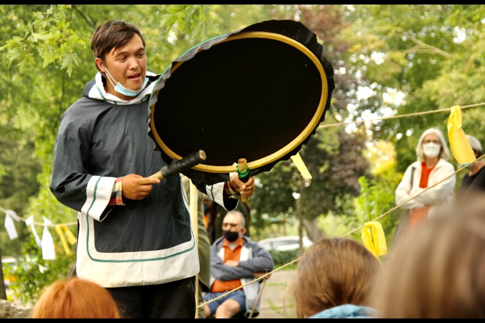 An Indigenous community member plays the drums for students at the sacred fire gathering held on Thursday for the National Day for Truth and Reconciliation at Royal City Park.