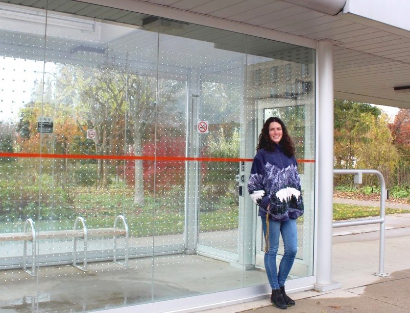 Hayley Wilson, founder of Bird Safe Guelph, stands beside a newly upgraded bus shelter.