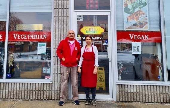 Owners of Kirtida's Kitchen, Hitesh Jagad and Kirtida Jagad stand in front of their restaurant. 