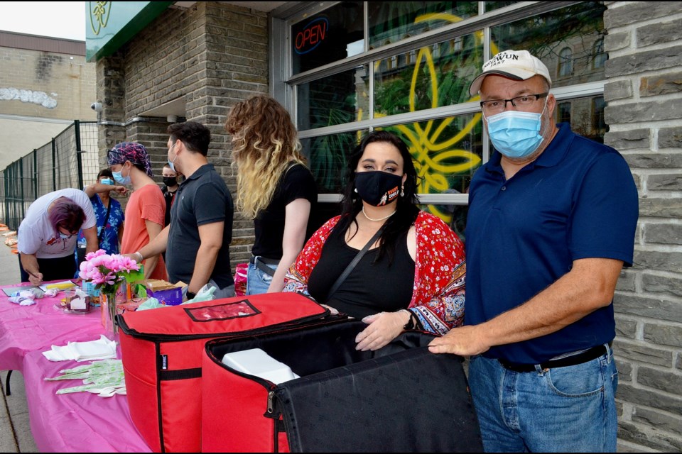 Kate Nixon and John Dennis help volunteers distribute meals and hygiene products in downtown Guelph Sunday afternoon