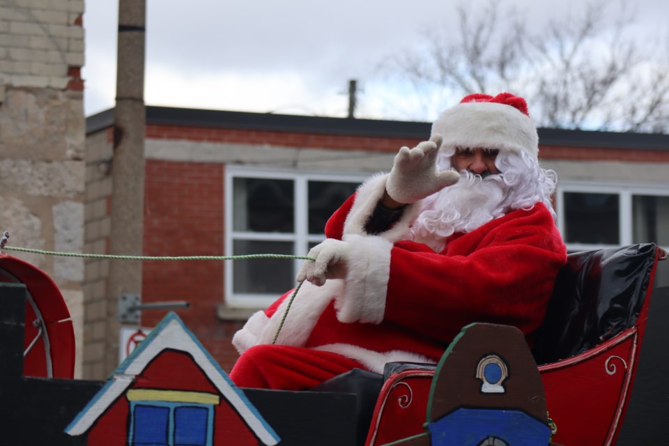 Santa Claus waves to children during the Fergus Santa Claus parade on Saturday.