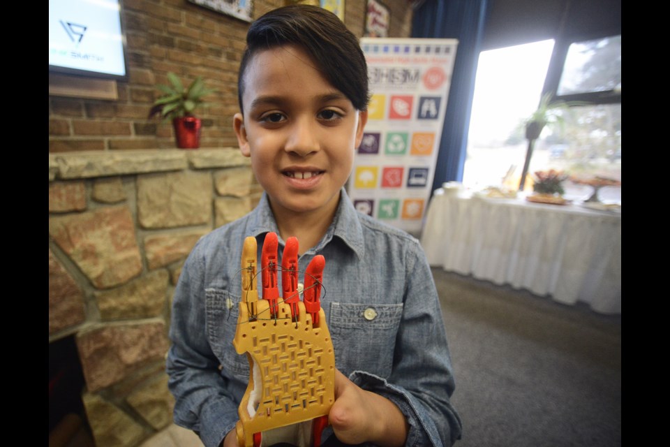 Jordan Singh, 7, holds the prosthetic hand Thursday, March 1, 2018, made for him by a 3D printer at College Heights Secondary School. Tony Saxon/GuelphToday