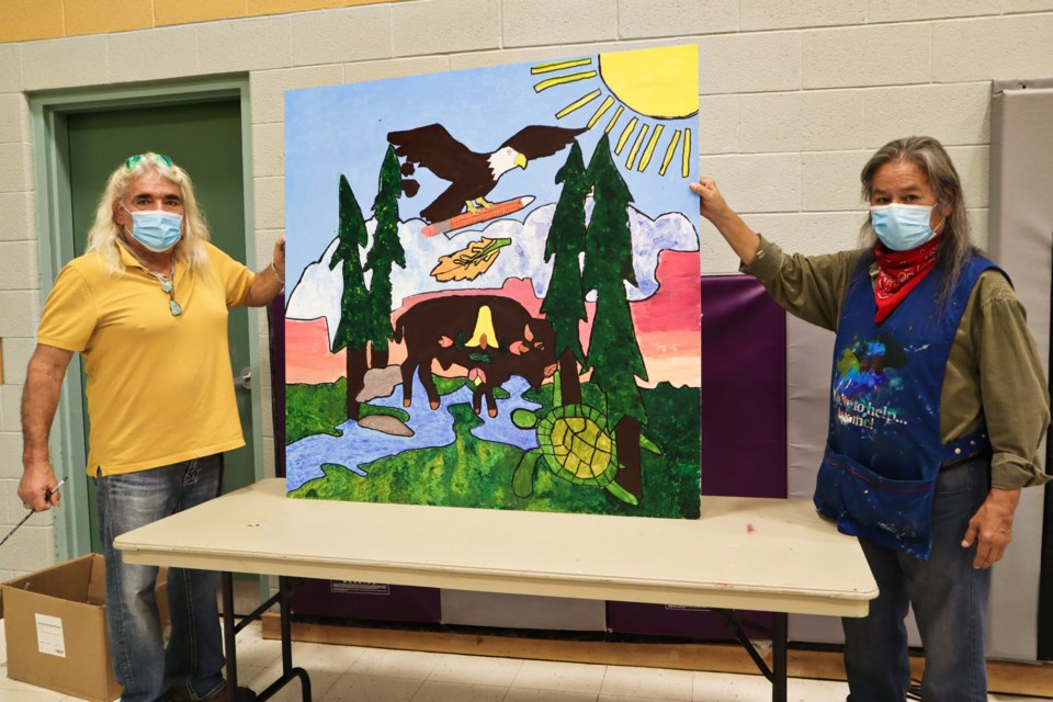 Gerry Ranger, left, and Michael 'Cy' Cywick, right, holding up a mural with the buffalo, which represents respect.