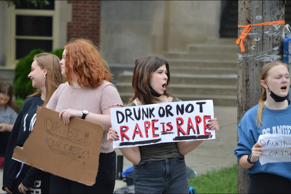 A student holds a sign as they protest outside GCVI on Friday.