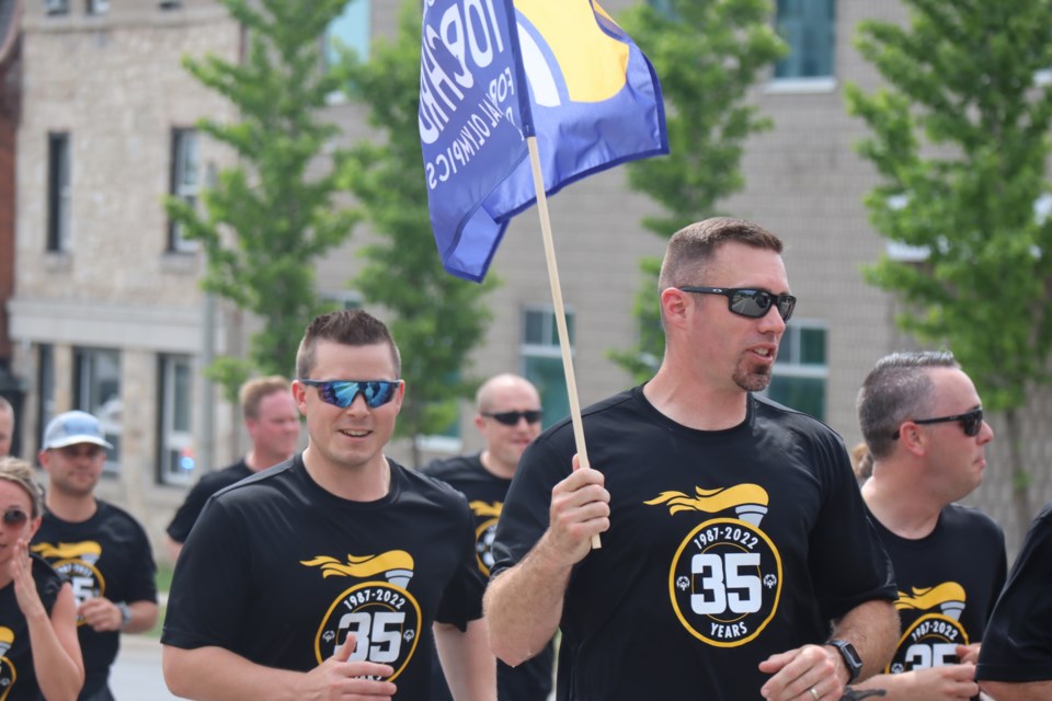 Man carries flag and leads the way for the Law Enforcement Torch Run.