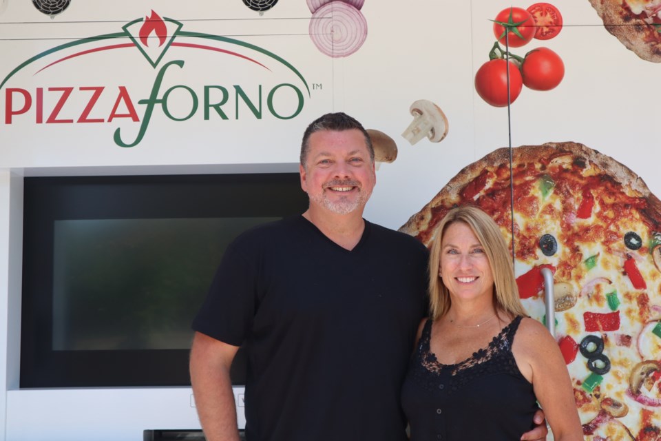 Mark Hurson and Lesley Bell outside their PizzaForno machine on the University of Guelph campus.