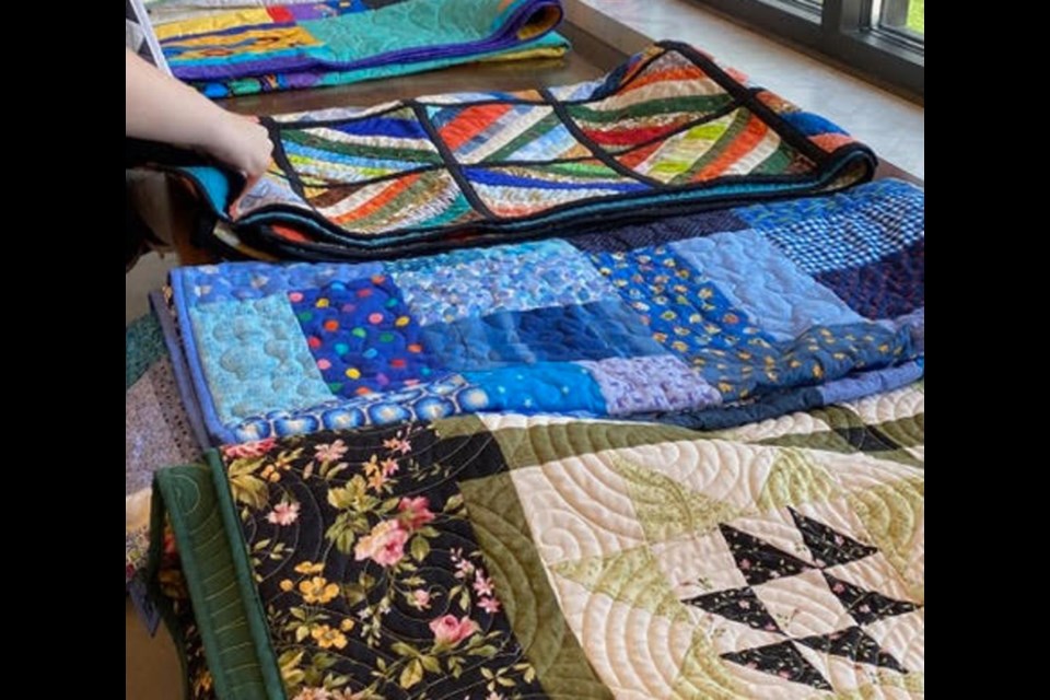 Choosing from a variety of quilts at Grace Gardens.