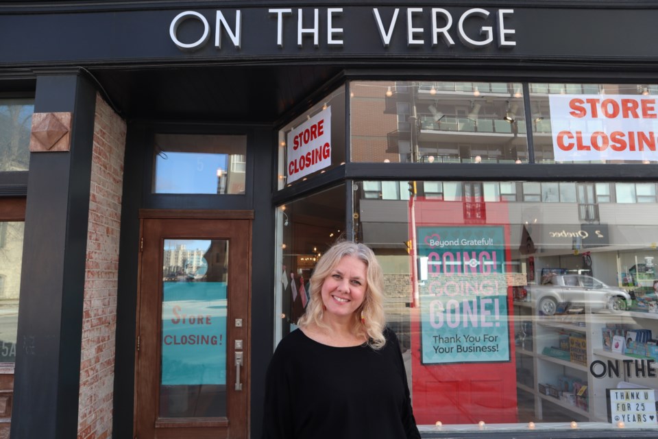 Cathy Cole, owner of On The Verge outside her store on 5 Quebec St. with store closing signs in the windows.