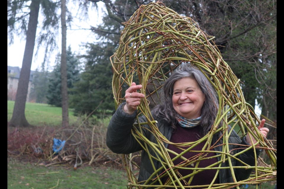 A Guelph artist with the creation she made for the stick weaving project.