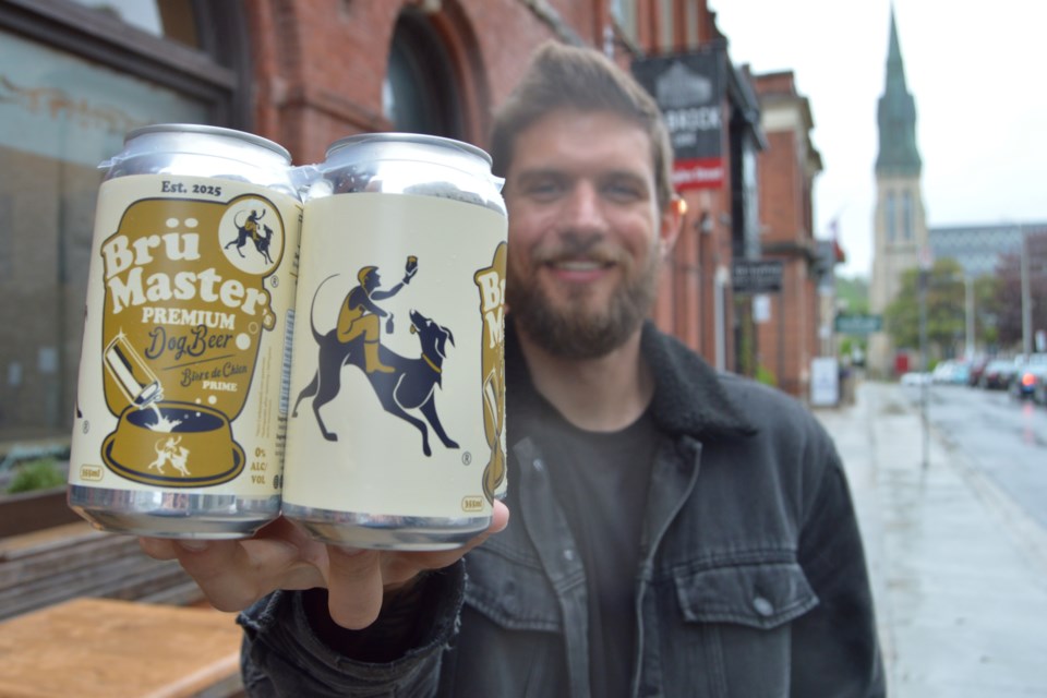 Asa Proveau holding a four-pack of  Brü Master’s Premium Dog Beer.