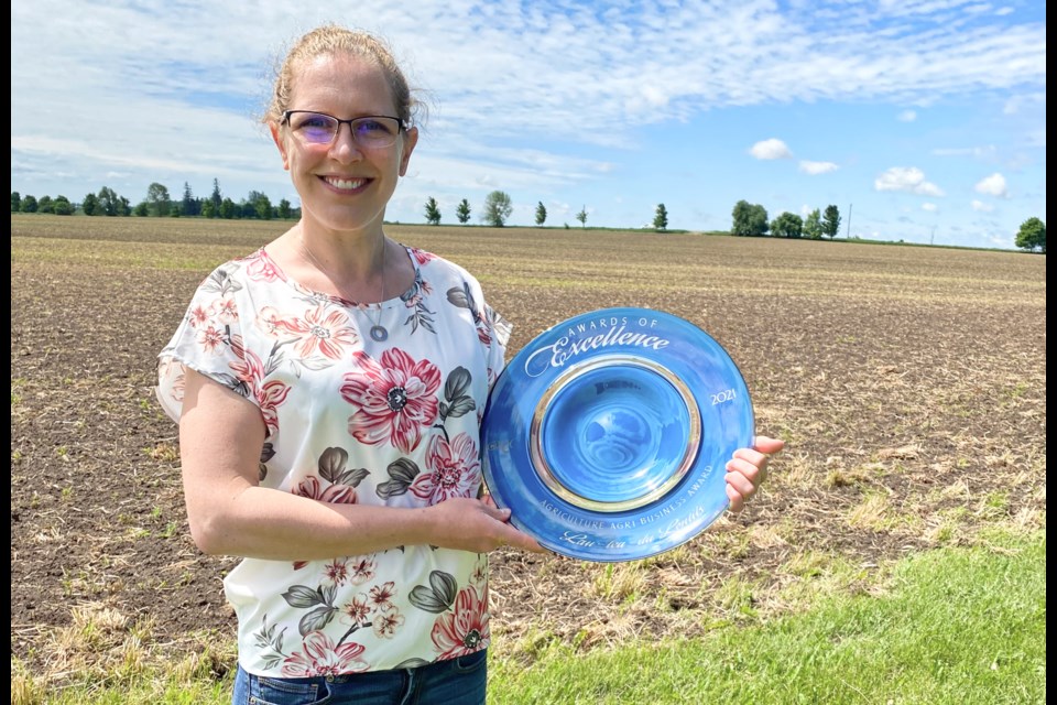 Laura Ferrier holding the 2022 Award of Excellence in agriculture - argi-business from the Centre Wellington Chamber of Commerce. 