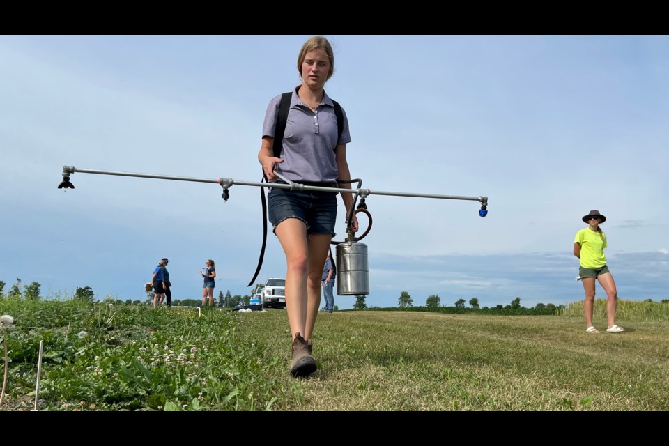 Hannah Symington practices the walk with a calibrated sprayer. In the Northeastern Weed Science Society's Collegiate Weed Science Contest, competitors will be scored on the amount of product they spray, their walking pace, the spray height and more during the team spraying event. 