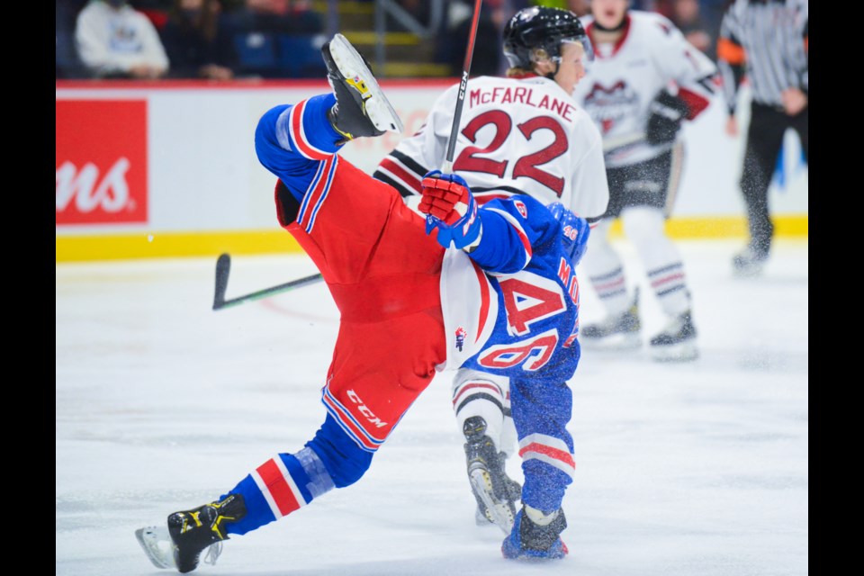 Ben McFarlane of the Guelph Storm rocks Kitchener Ranger Simon Motew with an open-ice check Sunday at the Sleeman Centre.