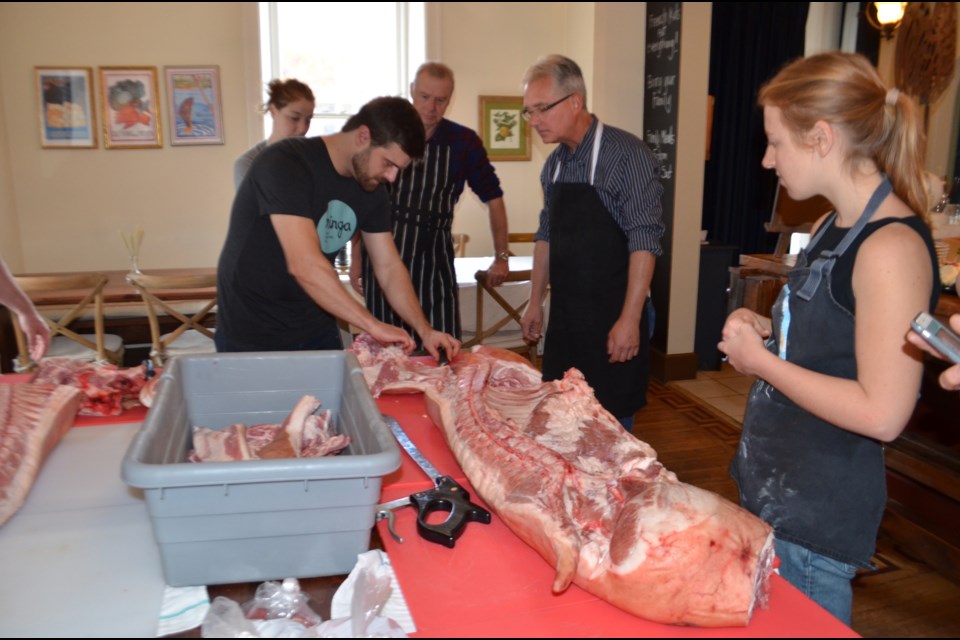Butcher Wesley Clarke teaches workshop participants how to butcher a side of pork. Photo by Troy Bridgeman for GuelphToday.