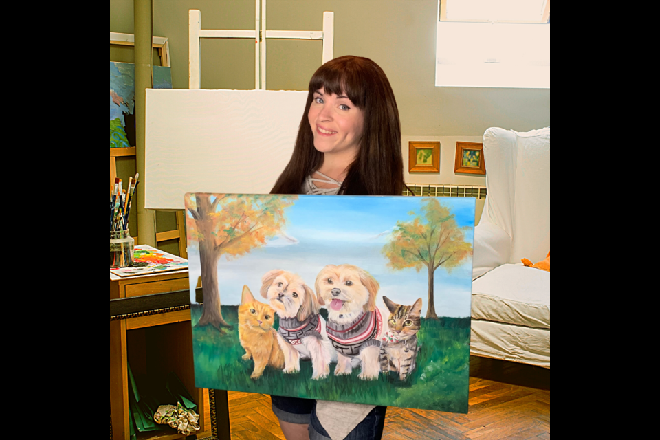 Guelph artist Rae Wright poses with a custom painting she made of a client's pets.