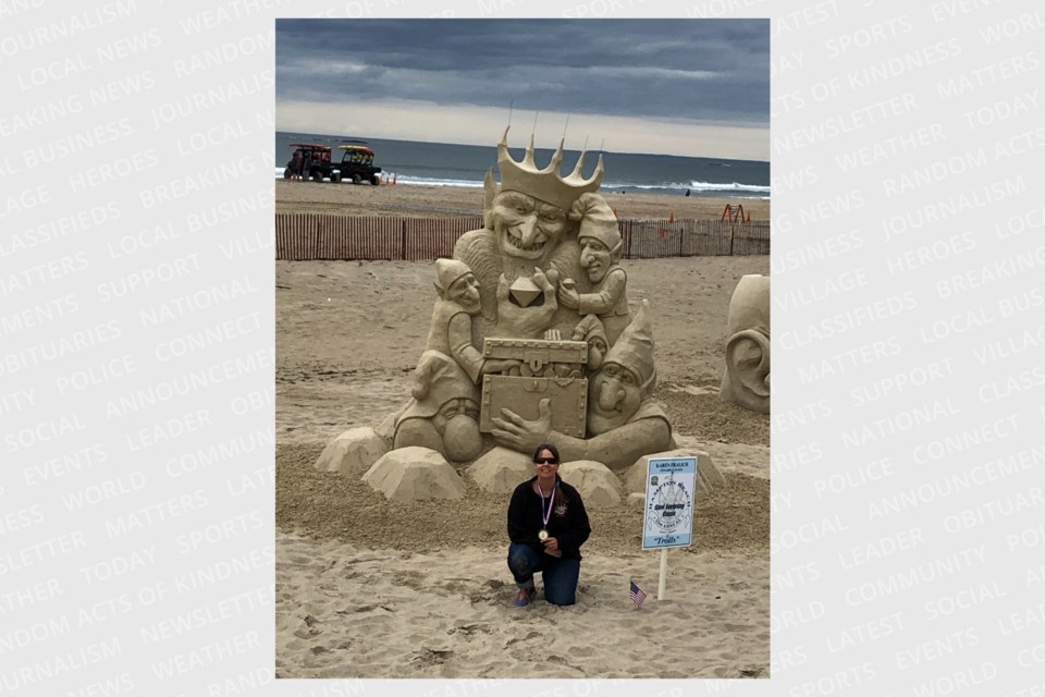 Karen Fralich poses in front of her sculpture "Trolls" in Hampton Beach, New Hampshire earlier this year.