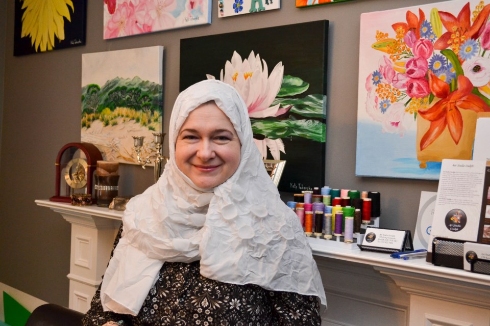 Kate Salih, Owner of Art Studio Guelph, standing with her artwork, Photo by Daniel Bell for GuelphToday. 