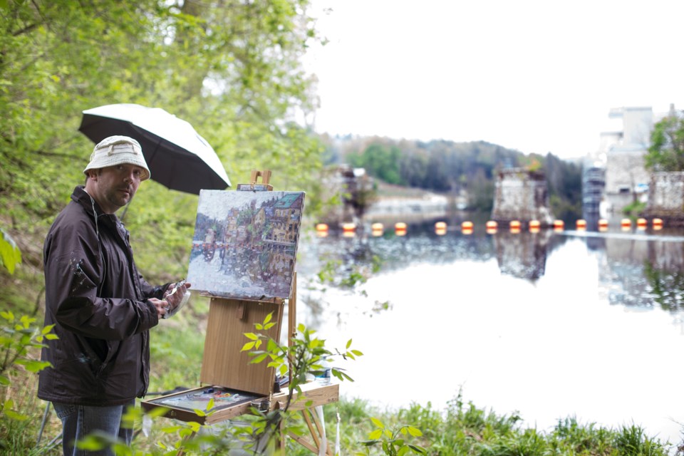 Michael Brennan paints a scene on Elora's waterfront for one of his possible entries in the Elora en Plein Air painting festival. Kenneth Armstrong/GuelphToday