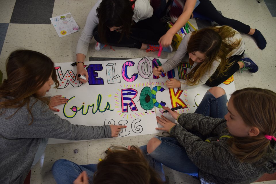 Girls from the Girls Rock Camp make a sign for Saturday night's final performance at John McCrae Public School. Rob O'Flanagan/GuelphToday