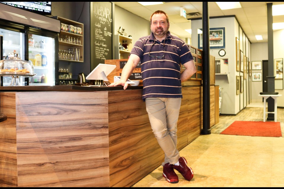 Rick Green leans against the counter inside the DeBAR Dessert Cafe. 