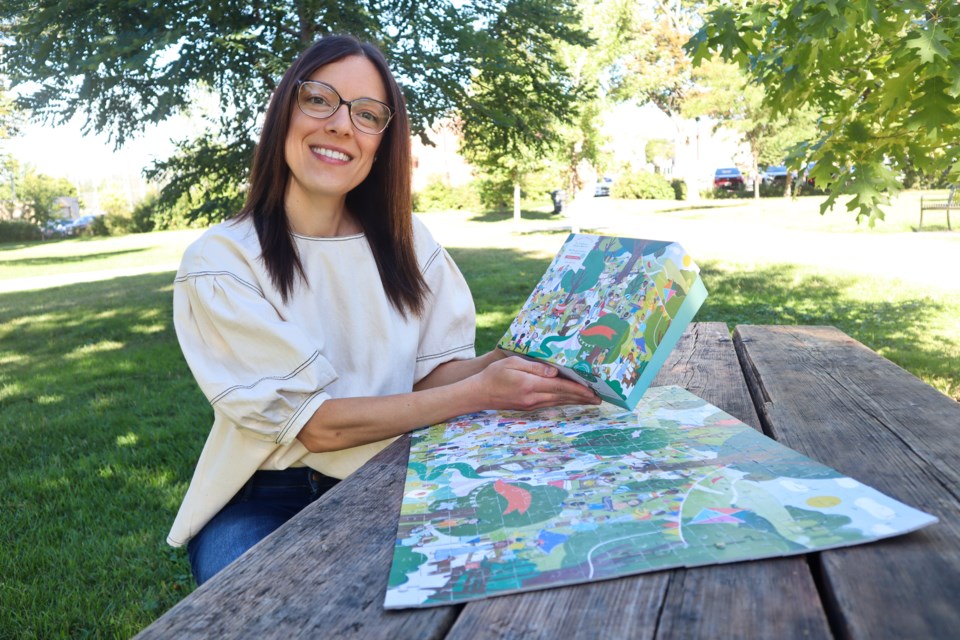 Ashley Kizis, founder of Kidunified, sitting with her first puzzle, 'The Children's Maker Market Puzzle.' 