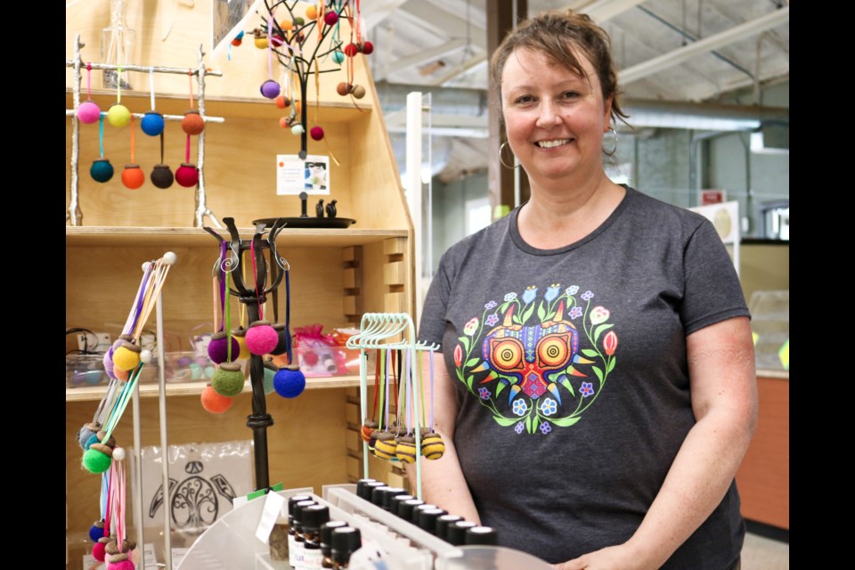 Lisa June Byers poses with their stand at the Guelph Farmers' Market.