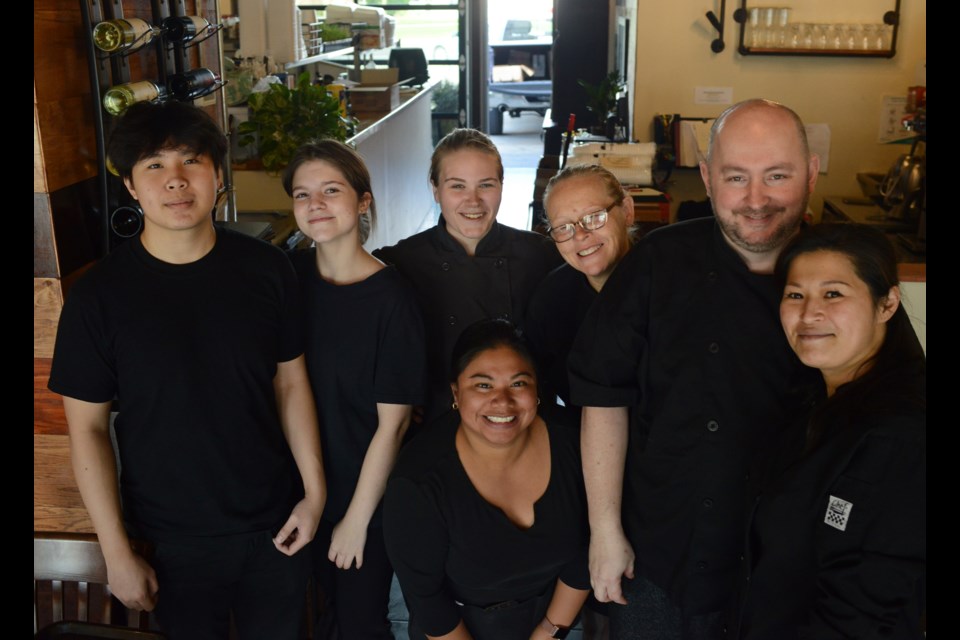 Staff and volunteers at Queen's Café, including owners Ron Hill and Tammy Hsieh, right, pose for a photo in the restaurant on Monday as hey prepare to serve 100 free Thanksgiving dinners as a way of giving back to the community. Tony Saxon/GuelphToday