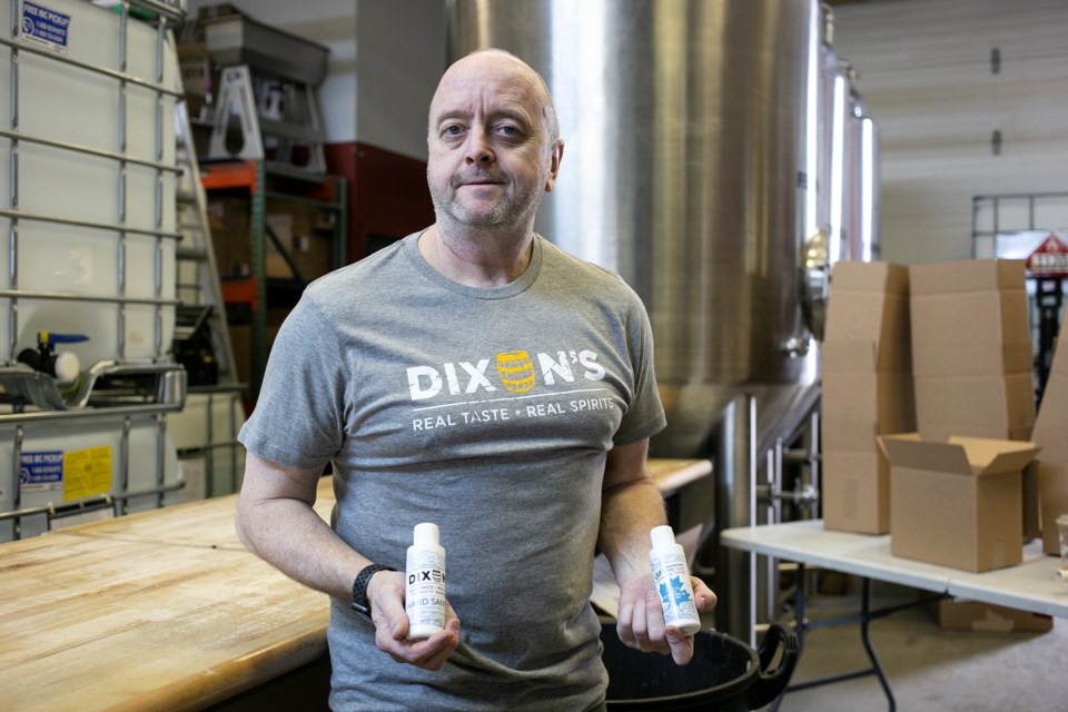 Volunteer Larry Gable holds up bottles of hand sanitizer produced at Dixon's Distilled Spirits in Guelph. The hand sanitizer is being distributed for free to local health care providers and frontline workers. Kenneth Armstrong/GuelphToday