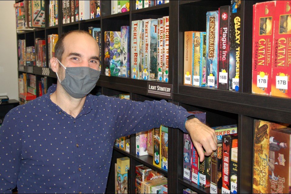 Manager Bradley Sivyer stands with some of the board game offerings at Snakes and Lattes on Wyndham Street North.