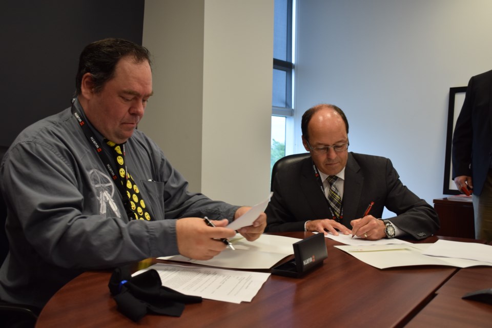Missanabie Cree First Nation chief Jason Gauthier, left, and Würth Canada CEO and president Ernie Sweeney sign a joint venture agreement to supply north mining operations on the First Nation's traditional territory. Rob O'Flanagan/GuelphToday