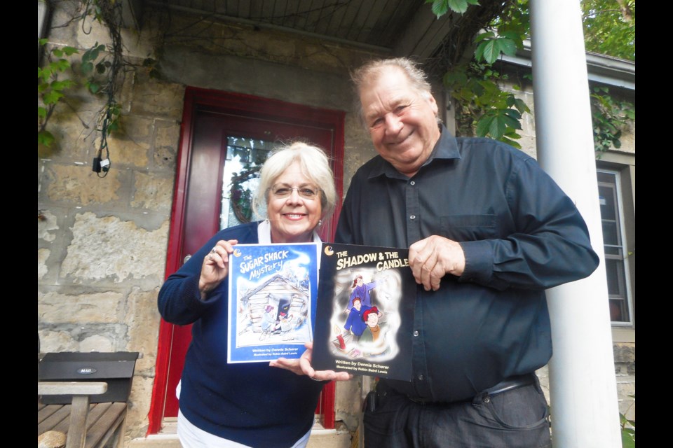 Illustrator Robin Baird Lewis, left, and author Dennis Scherer, right, pose with their second book, 'The Sugar Shack Mystery.'