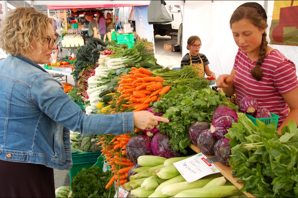 Jodie Gray picks out her produce purchase at Guelph Farmers' Market. The market runs on Saturdays from 8 a.m. to 1 p.m. year-round and Thursdays from 4 to 7 p.m. June through October.