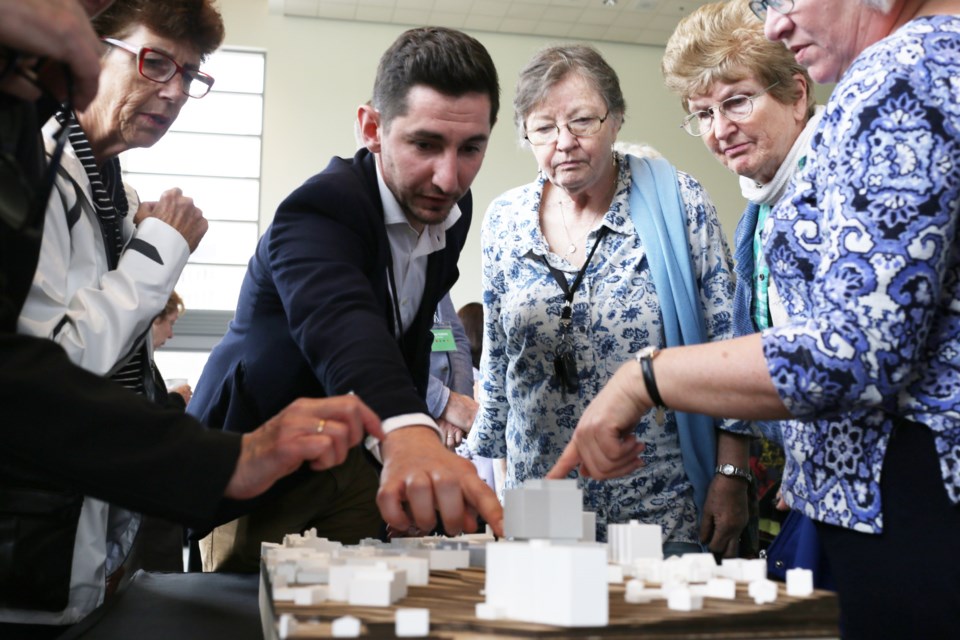People at an open house for the Baker District Redevelopment look at models of the proposed new central library building and attached 14-storey living space. Kenneth Armstrong/GuelphToday