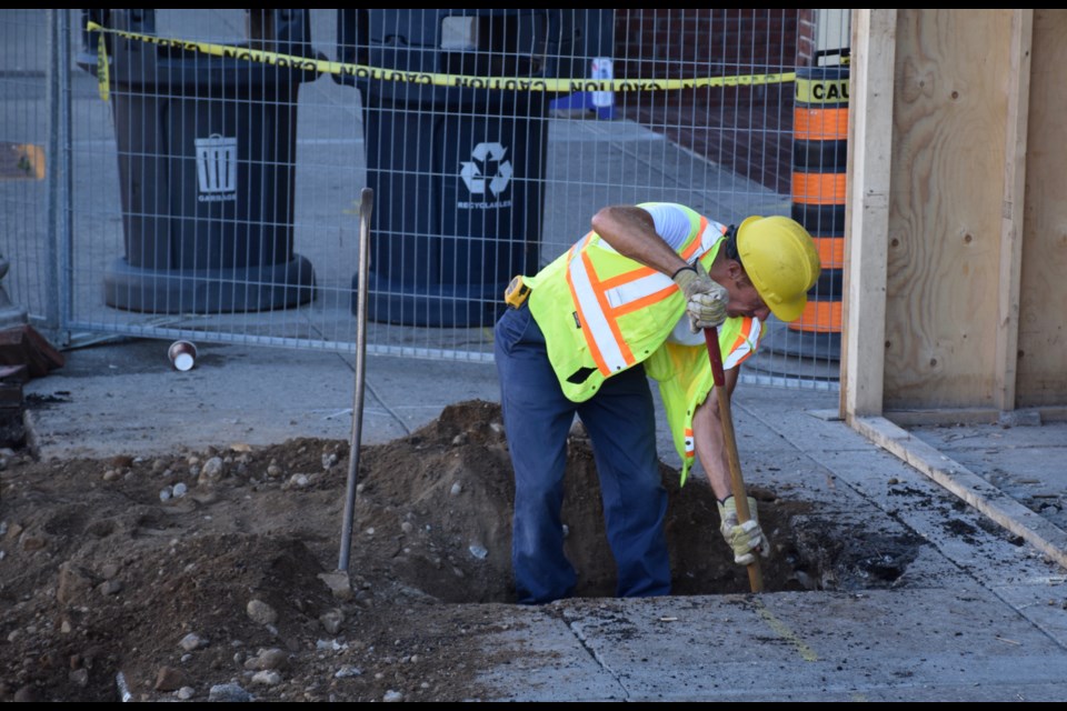 A worker digs into Wyndham Street near the historic Petrie Building. 