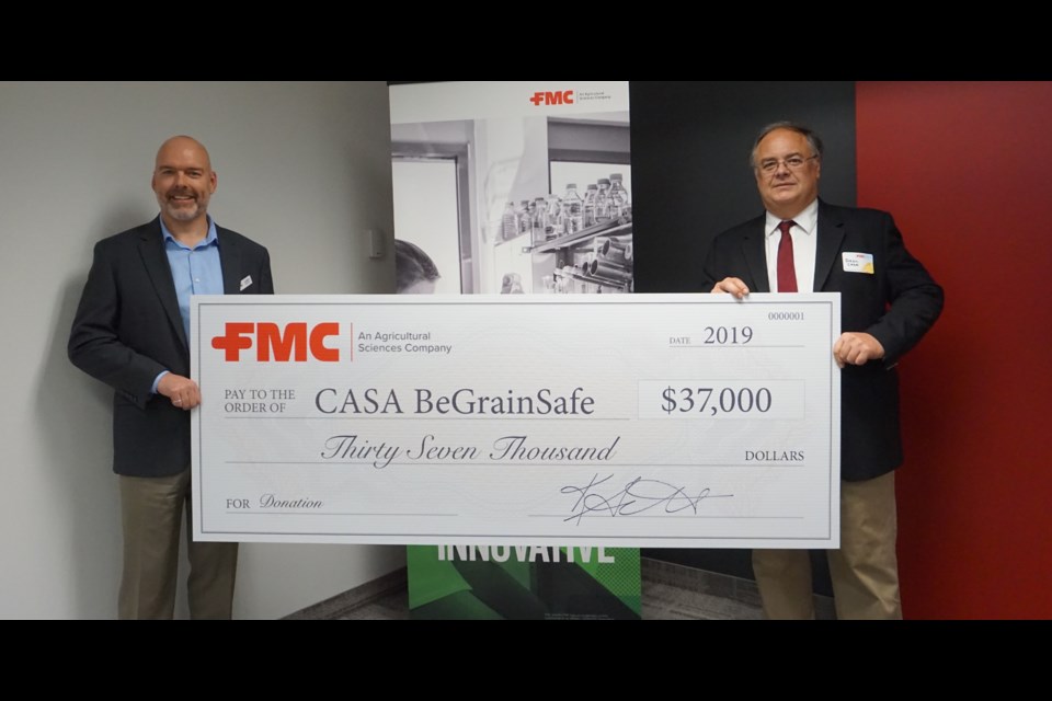 Guelph's Dean Anderson (right) accepts this donation from FMC Canada Country Manager Darren Dillenbeck in support of the BeGrainSafe program. Photo by Joey Sabljic