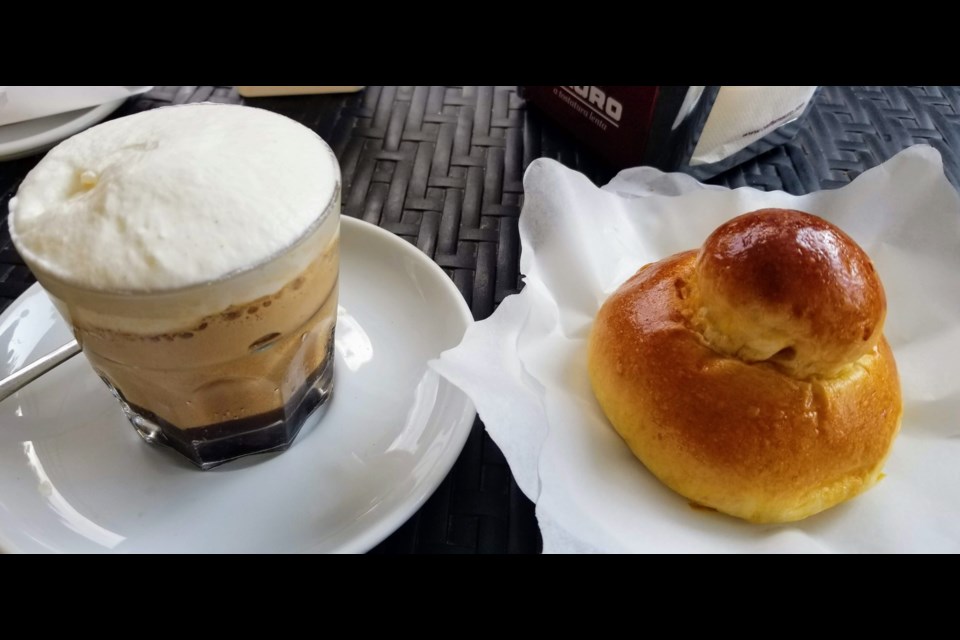 Granita di Caffe con Panna or coffee granita with whipped cream,  photographed in Messina, Sicily (shown with a fresh brioche bun).