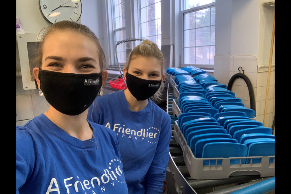 Founders of A Friendlier Company Jacquie Hutchings and Kayli Dale stand alongside their reusable containers as they go through the sterilization process and are prepared for another use.