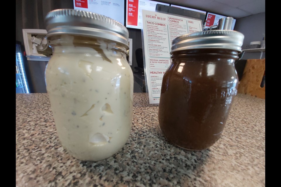 Jars of Lucky Belly's garlic aioli and balsamic vinegarette are among the house-made salad dressings now being sold for people to take home.