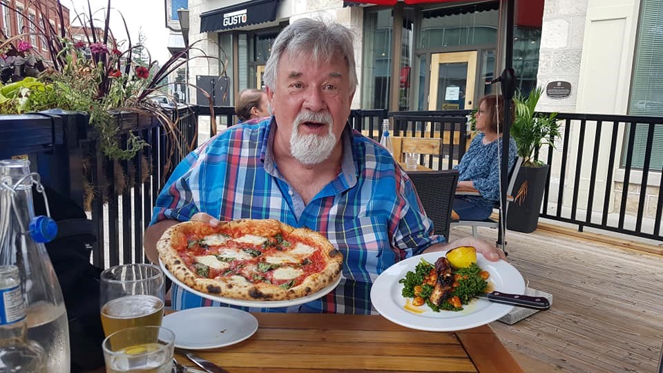 The Kitchenman, Wayne Conrad Serbu, enjoys some Buon Gusto pizza.