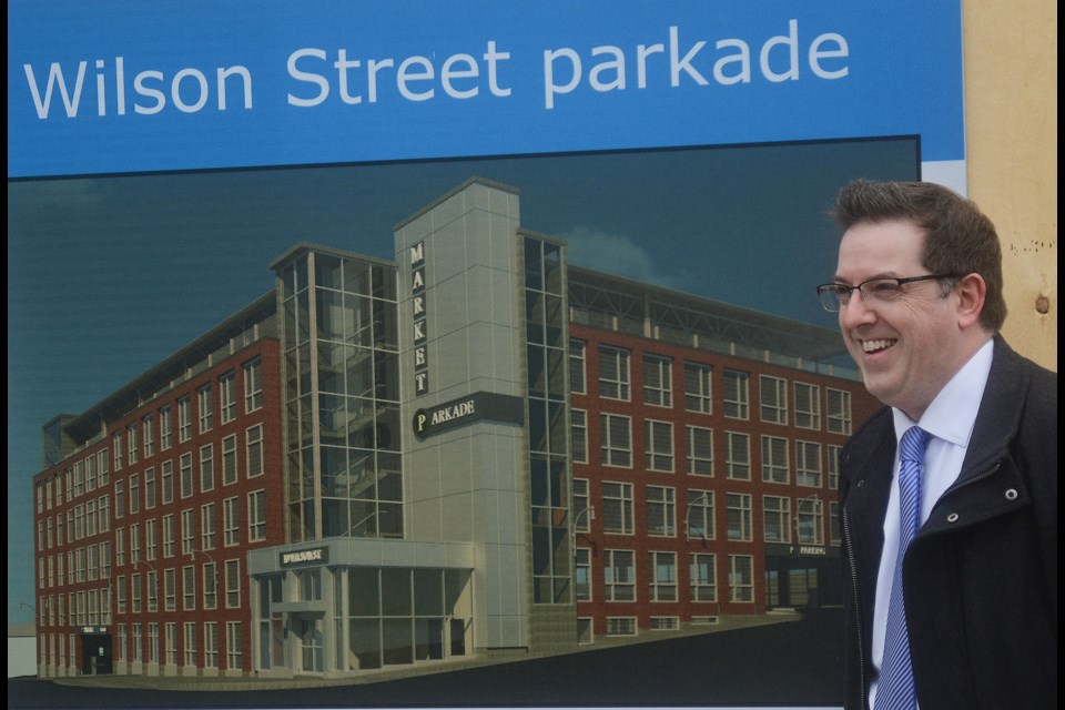 Mayor Cam Guthrie poses beside a n artists rendition of what the new Wilson Street parkade is going to look like Thursday, Feb. 22, 2018. Tony Saxon/GuelphToday