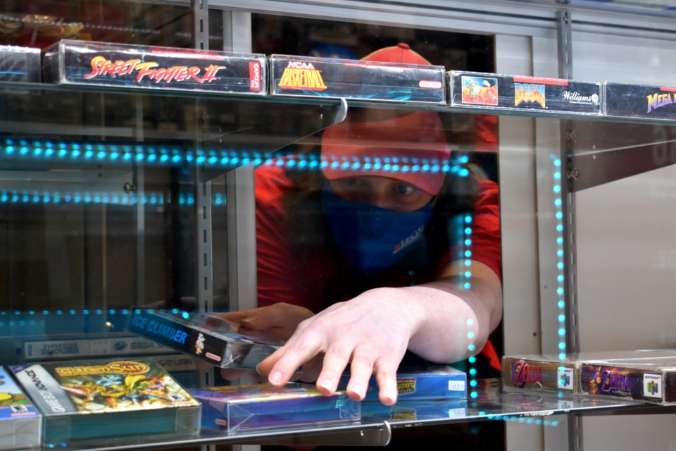 Brodie Beamish stocks the shelves in his new store with retro video games.