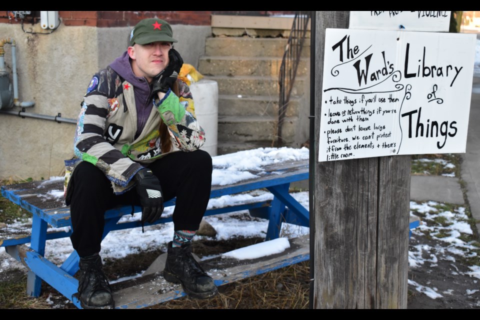 Danny Drew sits on the former bench that held the Ward's Library of Things. Daniel Caudle/GuelphToday