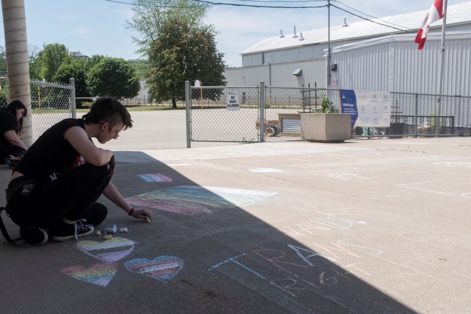 Rayden Balla uses chalk to show support at the site of where a Pride Flag was vandalized at Sacred Heart Catholic School on Saturday. Kenneth Armstrong/GuelphToday