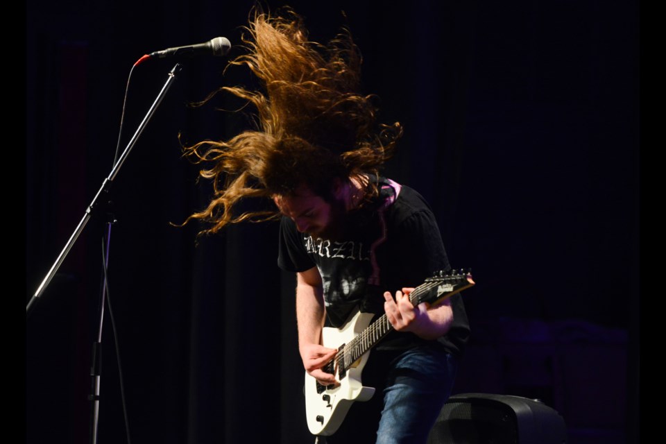 A guitarist for Tortugal Sacrifice rocks out at the annual Catholic high school battle of the bands Wednesday at Lourdes high school. They represented St. James.