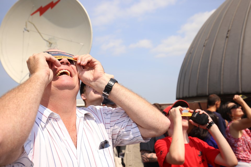 Terry Van Raay views today's eclipse on the rooftop of the MacNaughton Building on the University of Guelph campus. Although the event was a total solar eclipse, in our area it was only viewable as a partial eclipse. Kenneth Armstrong/GuelphToday