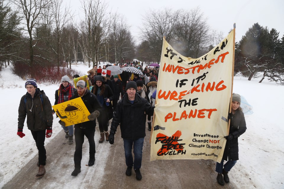 Fossil Free Guelph members and supporters toward the Arboretum Centre en route to U of G's Board of Governors meeting on Wednesday. The university decided not to divest its approximately $30 million in fossil fuel investments. Kenneth Armstrong/GuelphToday