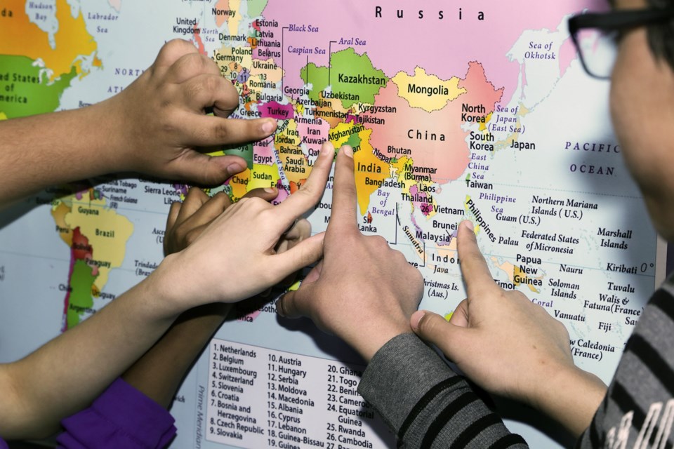 Some students at Willow Road Public School point out their home countries on a map in the school's hallway. A total of 41 languages are understood by students and staff in the school. Kenneth Armstrong/GuelphToday